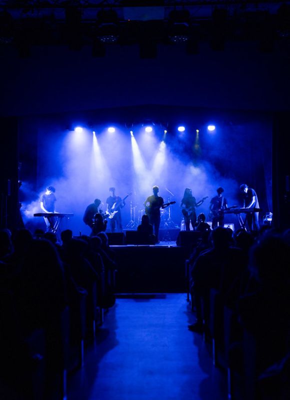 Concerto live della Scuola di Musica Cluster con studentessa cantante e band di accompagnamento.