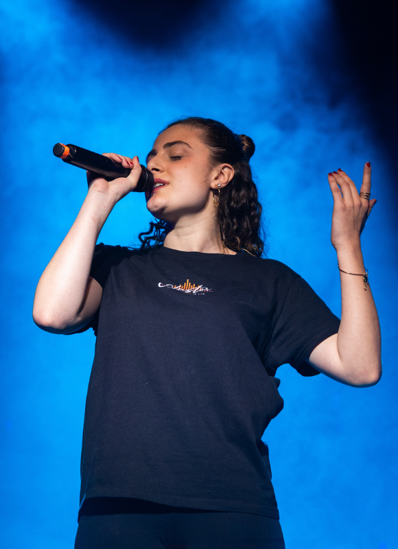 Studentessa della Scuola di Musica Cluster canta dal vivo durante una performance con band